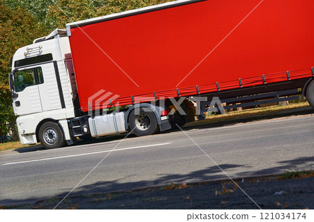 Delivery. Heavy red trailer for long distance transportation.Place for text Delivery. Heavy red trailer for long distance transportation.Place for text 121034174