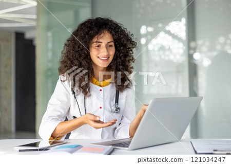 Smiling female doctor engaging in online consultation, showcasing telemedicine advancement. Confident healthcare professional utilizing laptop for telehealth in modern medical office. Smiling female doctor engaging in online consultation, showcasing telemedicine advancement. Confident healthcare professional utilizing laptop for telehealth in modern medical office. 121034247