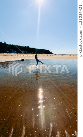 Teenage boy dancing in the sun on the shore of the White Sea Teenage boy dancing in the sun on the shore of the White Sea 121034421