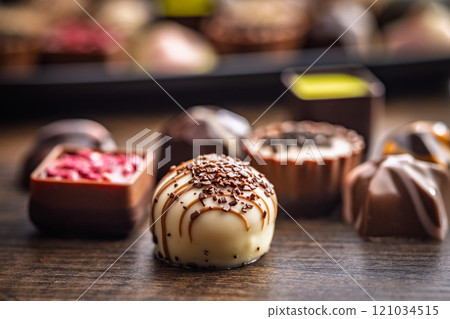 Mix of chocolate pralines on wooden table. 121034515