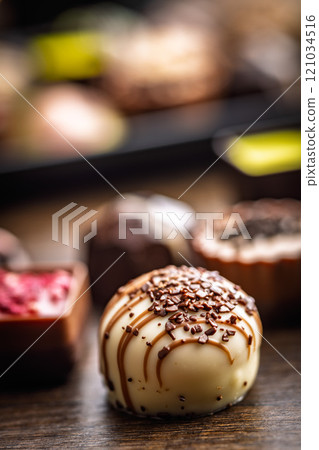 Mix of chocolate pralines on wooden table. 121034516