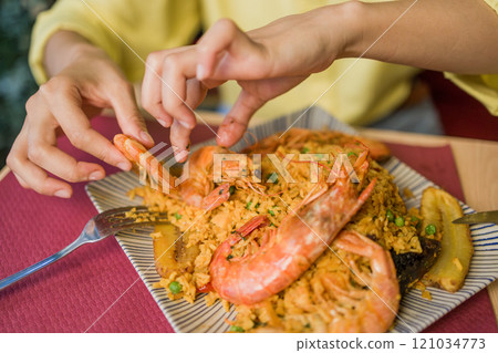 Arroz marinero Ecuadorian cuisine, traditional food, rice recipe with seafood. Hands closeup eating Arroz marinero Ecuadorian cuisine, traditional food, rice recipe with seafood. Hands closeup eating 121034773