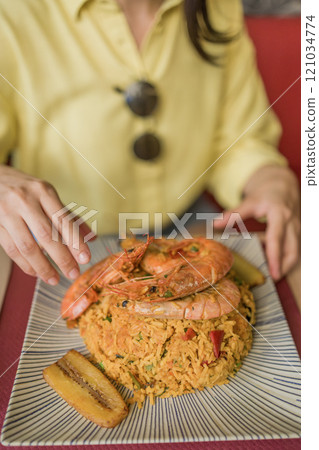 Arroz marinero Ecuadorian cuisine, traditional food, rice recipe with seafood. Hands closeup eating 121034774