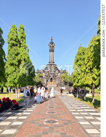 Editorial image of the iconic Bajra Sandhi Monument in Denpasar, Bali, surrounded by lush greenery and visitors exploring the cultural landmark. 121037017