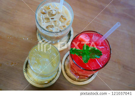 A variety of takeaway drink options, including iced coffee, tea, and juices, in transparent cups with straws. drinks are colorful and refreshing, appealing to a wide range of tastes. A variety of takeaway drink options, including iced coffee, tea, and juices, in transparent cups with straws. drinks are colorful and refreshing, appealing to a wide range of tastes. 121037041