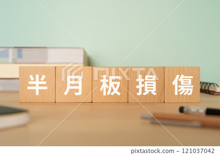 A desk with a block with the words "Meniscus injury" written on it A desk with a block with the words "Meniscus injury" written on it 121037042
