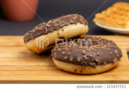 Glazed donuts with a plate of waffles and cup on the table Glazed donuts with a plate of waffles and cup on the table 121037721