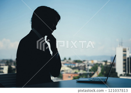 在辦公室辦公桌前工作的商人（憂慮、思考、分析、剪影） 121037813