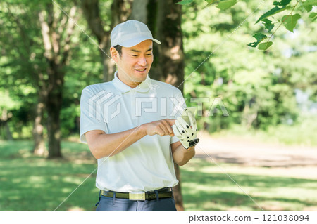 Male golfer using smartphone on golf course (app, score, score management, course strategy, course map) 121038094