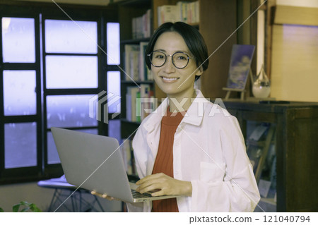 A middle-aged woman working on a computer in an old-style cafe 121040794