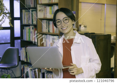 A middle-aged woman working on a computer in an old-style cafe 121040796