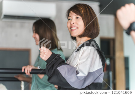 Asian woman walking and doing aerobic exercise using a treadmill/running machine in a sports gym Asian woman walking and doing aerobic exercise using a treadmill/running machine in a sports gym 121041609