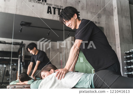 Men who are sports therapists and sports trainers who massage 121041613