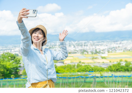 A woman taking pictures of beautiful scenery with her smartphone. A woman traveling. 121042372
