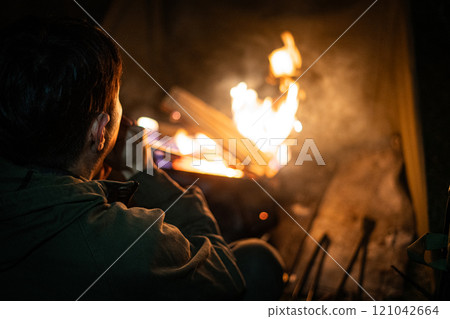 A man enjoying a bonfire with a blowtorch A man enjoying a bonfire with a blowtorch 121042664