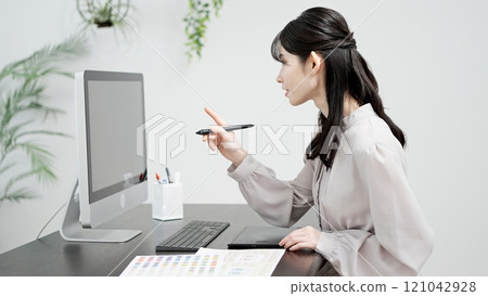 A creative woman working on a computer 121042928