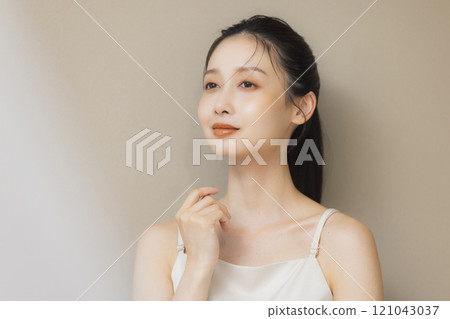 一個女人用手摀著臉微笑 一個女人用手摀著臉微笑 121043037