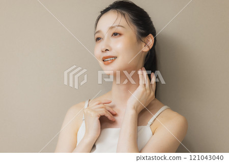 一個女人用手摀著臉微笑 121043040