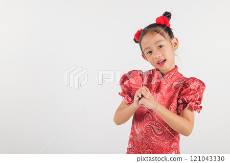 Happy Chinese New Year Asian girl in traditional red cheongsam qipao dress making a congratulatory gesture. Perfect for festive themes, isolated on a white Happy Chinese New Year Asian girl in traditional red cheongsam qipao dress making a congratulatory gesture. Perfect for festive themes, isolated on a white 121043330