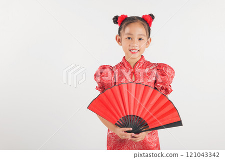 Happy Chinese New Year Asian girl wearing a red cheongsam smiles while holding a traditional fan. Isolated on white background, this festive portrait highlights cultural beauty Happy Chinese New Year Asian girl wearing a red cheongsam smiles while holding a traditional fan. Isolated on white background, this festive portrait highlights cultural beauty 121043342