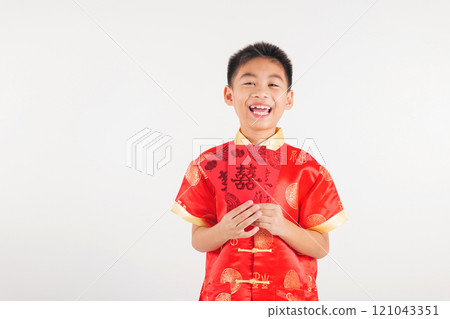 Happy Chinese New Year Asian boy in a red cheongsam qipao holds a monetary gift angpao red envelope. A traditional festive portrait showcasing joy and blessings. Isolated on white 121043351