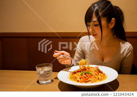 Young woman eating Neapolitan spaghetti Young woman eating Neapolitan spaghetti 121043424