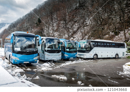 Intercity buses parked near the mountain forest at winter Intercity buses parked near the mountain forest at winter 121043668