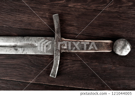 Medieval sword on wooden backgrond. Medieval sword on wooden backgrond. 121044005