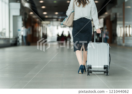 出差或帶著手提箱在車站旅行回來的女商人的腳 出差或帶著手提箱在車站旅行回來的女商人的腳 121044062