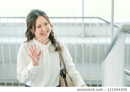 A woman/business woman climbing the stairs in the office (morning, going to work, going to work, commuting) 121044308