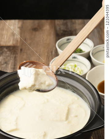Onsen tofu, Yudofu, tofu boiled in a clay pot, scooped up with a ladle Onsen tofu, Yudofu, tofu boiled in a clay pot, scooped up with a ladle 121044395