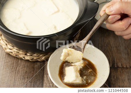Onsen tofu, Yudofu, tofu boiled in a clay pot, lifted with a spoon Onsen tofu, Yudofu, tofu boiled in a clay pot, lifted with a spoon 121044508