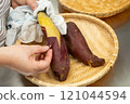 Making dried sweet potatoes - Peeling hot sweet potatoes 121044594