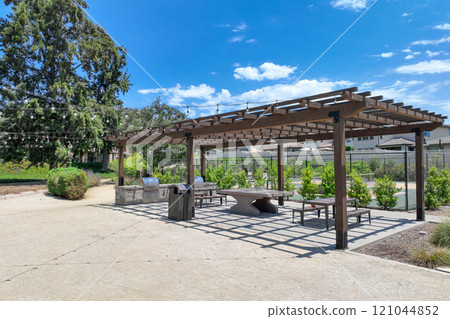 Covered gathering area in city park with green wood picnic tables Covered gathering area in city park with green wood picnic tables 121044852
