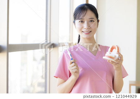 Dental hygienist who teaches tooth brushing 121044929
