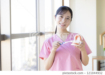 Dental hygienist who teaches tooth brushing 121044932