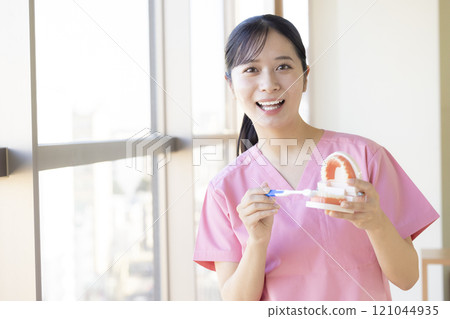 Dental hygienist who teaches tooth brushing Dental hygienist who teaches tooth brushing 121044935