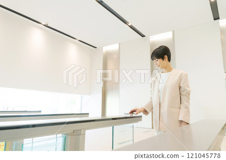 A woman passing through the security gate at the office 121045778