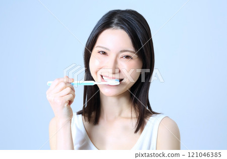 Image of a woman brushing her teeth Image of a woman brushing her teeth 121046385