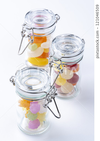 Glass jars filled with colorful sweets Glass jars filled with colorful sweets 121046509