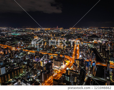 Vibrant city life in Osaka, Japan, a high vantage view of illuminated buildings and bustling roads at night captures the city's energetic spirit 121046662