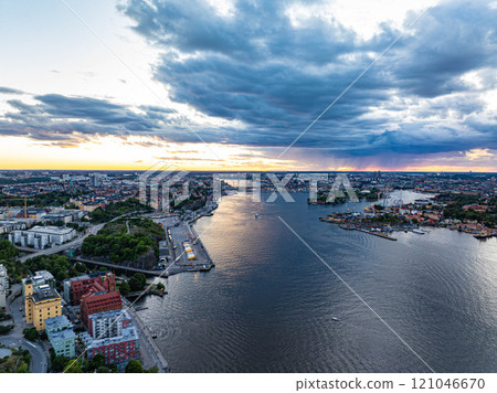 Stunning sunset view of Stockholm including Djurgarden with sailboats on Saltsjon waters, framed by dramatic clouds and blending urban landscape with nature of Sweden 121046670