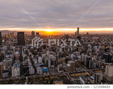 Stunning aerial view of Osaka, Japan, skyline at sunrise, showcasing modern skyscrapers, urban structures, and the beautiful warm tones of early morning light Stunning aerial view of Osaka, Japan, skyline at sunrise, showcasing modern skyscrapers, urban structures, and the beautiful warm tones of early morning light 121046683
