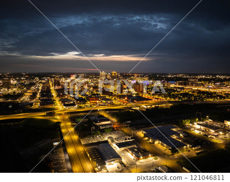 Birmingham, Alabama's mesmerizing city lights form a captivating pattern as night falls, casting a warm glow against the dramatic urban skyline 121046811