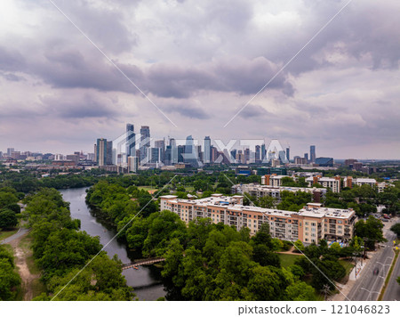 Austin, Texas skyline peeking through lush greenery and river, capturing the city's harmonious blend of urban and natural elements from above 121046823
