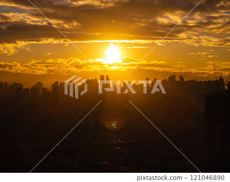 Glowing sunset casting stunning silhouette of Manila city skyline against golden clouds, showcasing the urban landscape 121046890