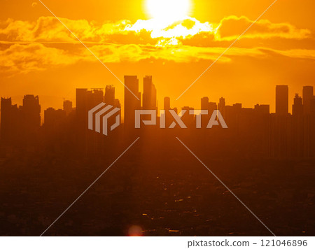 Manila city skyline glowing in warm golden hour sunlight, casting a captivating silhouette against a backdrop of vibrant orange clouds during sunset Manila city skyline glowing in warm golden hour sunlight, casting a captivating silhouette against a backdrop of vibrant orange clouds during sunset 121046896