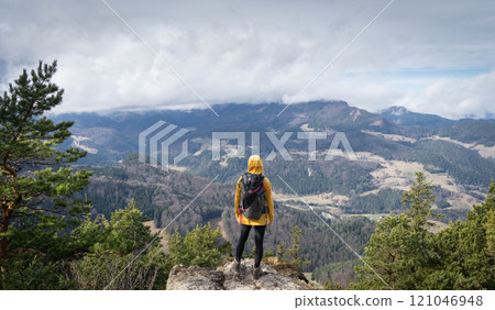 Female hiker on the top of the mountain enjoying the view on landscape down below, Austrian Alps Female hiker on the top of the mountain enjoying the view on landscape down below, Austrian Alps 121046948