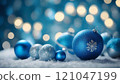 Christmas ornaments resting on snow with blue bokeh lights 121047199