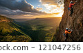 Group of climbers working together to scale a steep cliff, with one person assisting another as they ascend. The scene is set against a breathtaking backdrop of vast mountains, rolling hills, and a 121047256